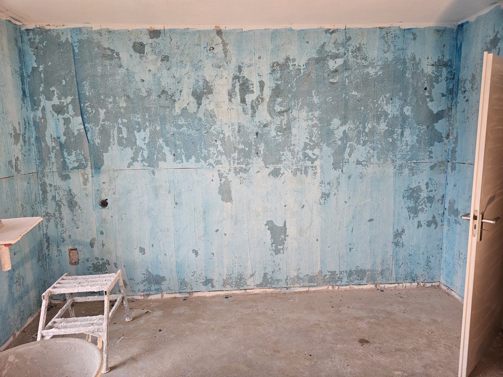 Verouderde, beschadigde wanden bij de start van een stucwerk-renovatie in Breda